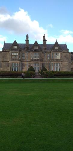 um grande edifício com um grande campo verde em frente em Lios Daire em Killarney