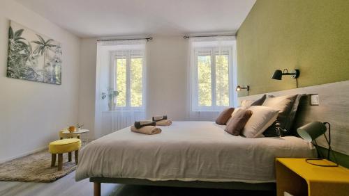 a bedroom with a large white bed with two windows at Bulles de sommeil - Cozy - RBNB in Mulhouse