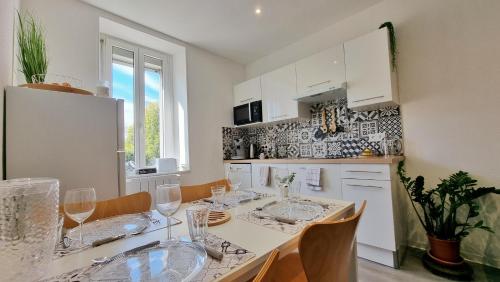 uma cozinha com uma mesa com copos de vinho em Bulles de sommeil - Cozy - RBNB em Mulhouse