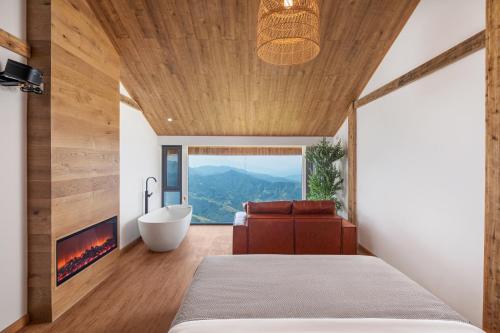 a bedroom with a fireplace and a bed and a tub at Rice View Lodge in Longsheng