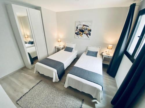 a bedroom with two beds and a mirror at Apartamento de obra nueva cerca de la playa by Top Stay in El Médano