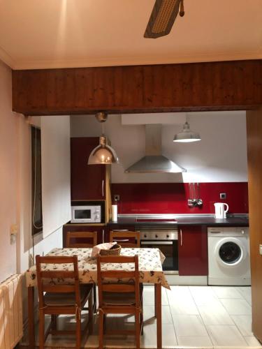uma cozinha com uma mesa e cadeiras numa cozinha em Apartamento Torrelavega em Torrelavega
