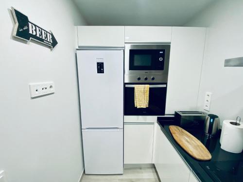 a kitchen with a refrigerator and a microwave at Apartamento de obra nueva cerca de la playa by Top Stay in El Médano