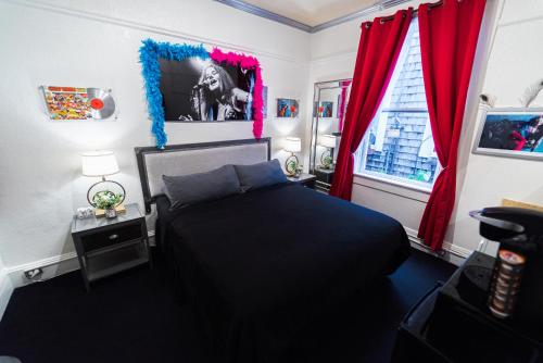 a bedroom with a black bed and red curtains at Music City Hotel - The San Francisco Music Experience in San Francisco