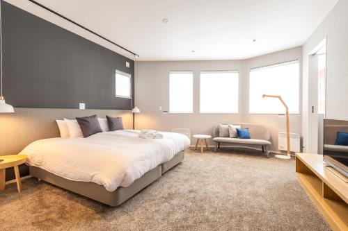um quarto com uma cama grande e um sofá em The Orchards Niseko em Niseko