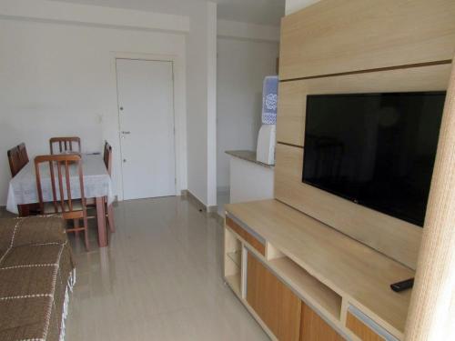 Una sala de estar con un televisor de pantalla plana grande. en Apartamento completo p temporada Ubatuba, excelente localização com conforto e economia, en Ubatuba