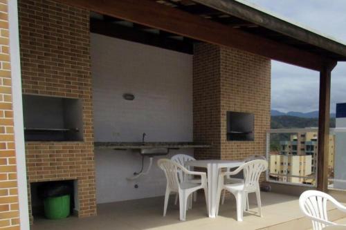 Un patio con una mesa y sillas en un balcón. en Apartamento completo p temporada Ubatuba, excelente localização com conforto e economia, en Ubatuba