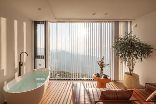 a bathroom with a tub and a large window at Rice View Lodge in Longsheng