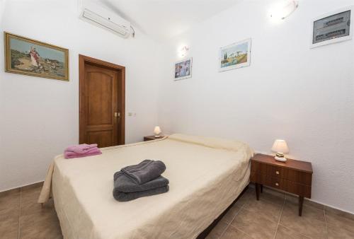 sypialnia z łóżkiem i dwoma ręcznikami na nim w obiekcie Bungalow Small House w mieście Stara Novalja