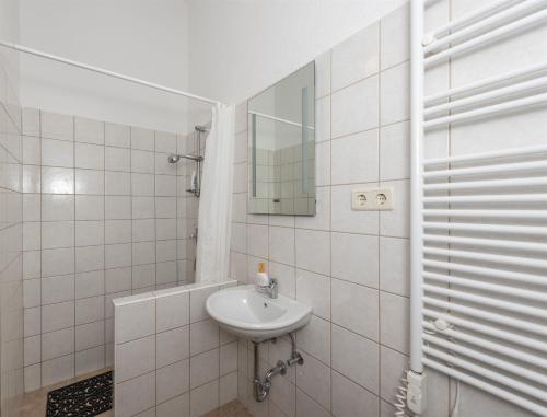 biała łazienka z umywalką i lustrem w obiekcie Bungalow Small House w mieście Stara Novalja