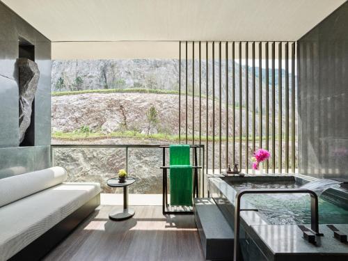 a living room with a tub and a large window at Banyan Tree Nanjing Garden Expo in Nanjing