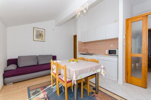een keuken en een woonkamer met een tafel en een bank bij Apartments Zoran in Drvenik