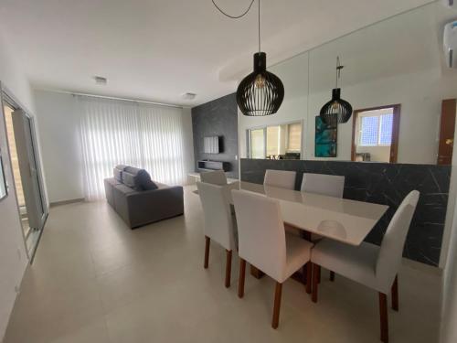 comedor y sala de estar con mesa y sillas en Apartamento Praia Grande, en Ubatuba