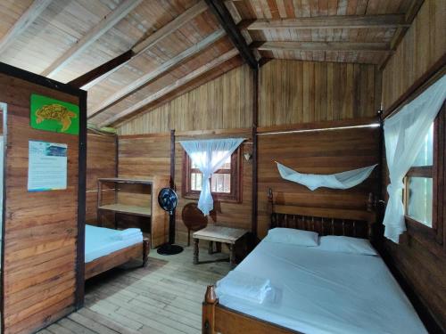 Un dormitorio con dos camas en una cabaña de madera. en Posada Don Aí, en El Valle