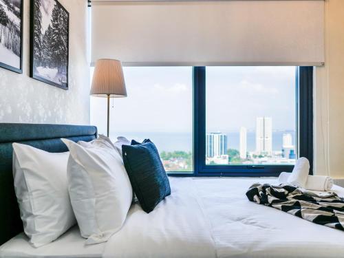 a bedroom with a bed with a large window at Tropicana 218 Macalister Studio with Seaview in George Town