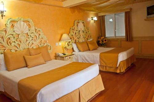 a hotel room with two beds with orange walls at Villa las Margaritas Plaza Cristal in Xalapa
