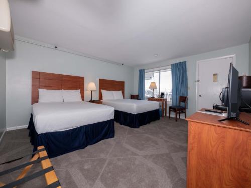 a hotel room with two beds and a flat screen tv at Sea Latch Inn in York Beach