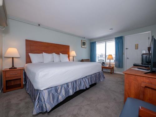 a hotel room with a large bed and a television at Sea Latch Inn in York Beach