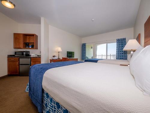 a hotel room with a large bed and a kitchen at Sea Latch Inn in York Beach