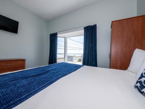 a bedroom with a bed and a large window at Sea Latch Inn in York Beach