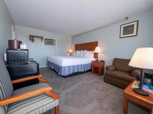 a hotel room with a bed and a couch and a tv at Sea Latch Inn in York Beach