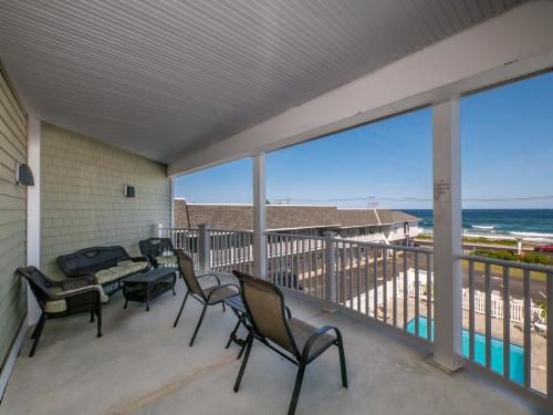 a balcony with chairs and a table with a view of the ocean at Sea Latch Inn in York Beach