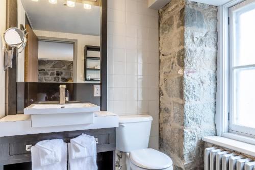 a bathroom with a sink and a toilet at Hotel Louisbourg in Quebec City