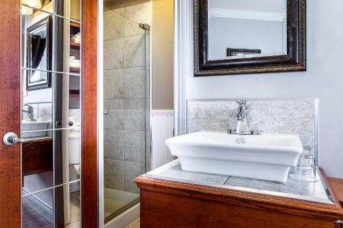 a bathroom with a white sink and a shower at Hotel Louisbourg in Quebec City