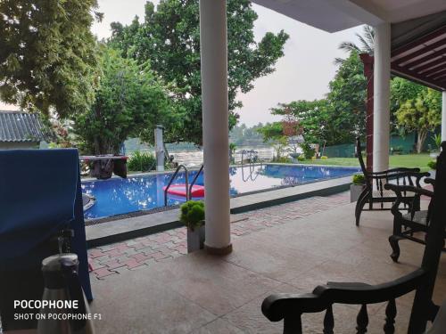 a view of a swimming pool from the porch of a resort at Residence Jasmine in Aluthgama