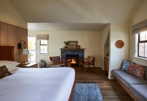 a bedroom with a bed and a couch and a fireplace at The Stavrand in Guerneville