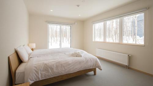 a bedroom with a bed and a window at Country Resort Niseko in Niseko