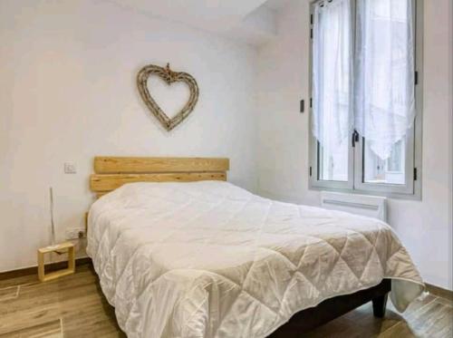 a bedroom with a bed and a heart sign on the wall at Morféo-le Vignemale in Cauterets