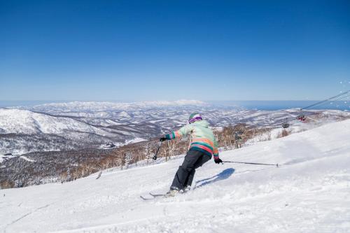 a person is skiing down a snow covered slope at Country Resort Niseko in Kutchan