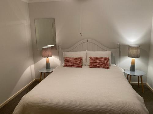 1 dormitorio con 1 cama blanca grande y 2 lámparas en Tanunda's Magpie House, en Tanunda