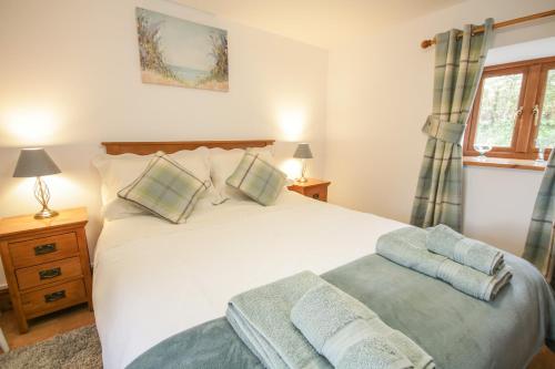 a bedroom with a large white bed and a window at Pendre Uchaf in Derwen