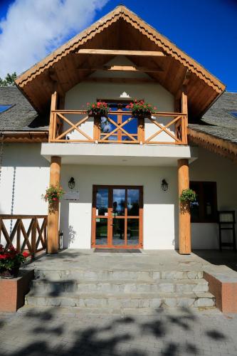 a house with a balcony with flowers on it at Pensjonat Bajdarka in Suraż
