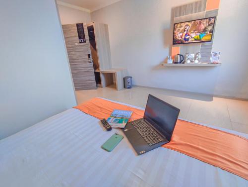 a laptop computer sitting on top of a bed at Front One Budget Waena Abepura in Abepura