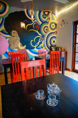 a dining room with a table and chairs and a painting at Funk Bunks - Mount View in Kandy