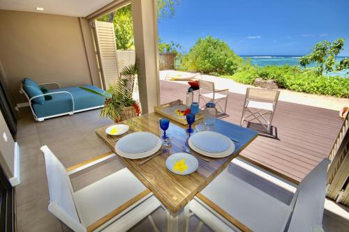 a dining table and chairs with a view of the ocean at Bacova Sur Mer by Le Domaine de Bacova in Pointe Au Sel 