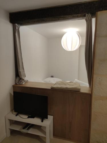 Pokój z telewizorem, lustrem i lampą w obiekcie Studio de charme, au calme dans le vieux Chaumont w mieście Chaumont