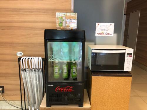 a coca cola refrigerator next to a microwave at Smile Hotel Tokushima in Tokushima