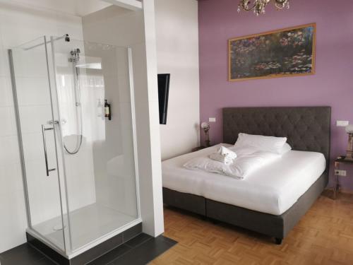 a bedroom with a bed with a glass shower at Altstadthotel Bachbräu in Weilheim in Oberbayern