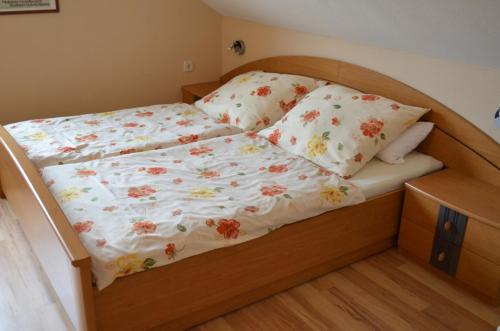 a bed with a floral bedspread and pillows on it at Ferienwohnung Silvia in Sankt Kanzian