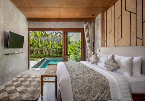 - une chambre avec un lit, une télévision et une piscine dans l'établissement Agrapana Beach Villa, à Gianyar