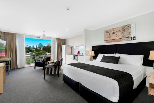 a hotel room with a large bed and a desk at The Wellington Apartment Hotel in Brisbane