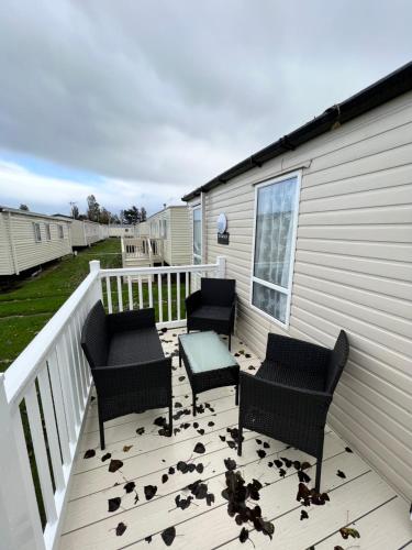 a deck with three chairs and a table on a house at Luxury Static Home 2 Bed Sleeps 6 in Great Yarmouth