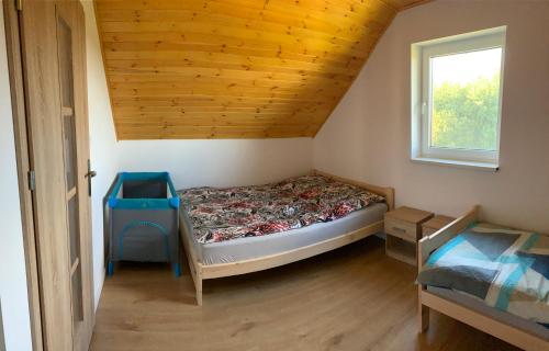 a bedroom with a bed in a room with a window at Ostoja Wilka in Grochowce