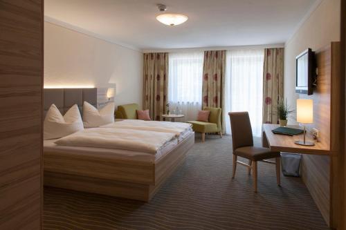 a hotel room with a bed and a desk at Hotel Straßhof in Pfaffenhofen an der Ilm