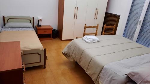 a room with two beds and a dresser and a table at Dalla Maria in Rimini