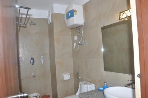 a bathroom with a shower and a toilet and a sink at Kunden Village Resort in Gangtok